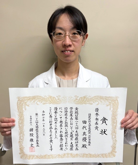 賞状を持つ田代真優研究科学生の写真